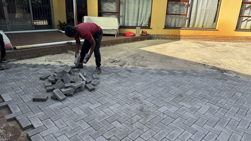 Shabco team placing pavers by hand on the courtyard job